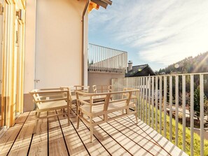 A wooden deck with outdoor furniture and a white railing. - Chalet #7 With 3 Bedrooms and Sauna (Oberwölz)