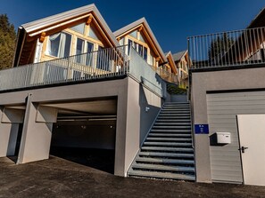 A modern building with a covered outdoor area, a staircase, and a garage. - Chalet #7 With 3 Bedrooms and Sauna (Oberwölz)