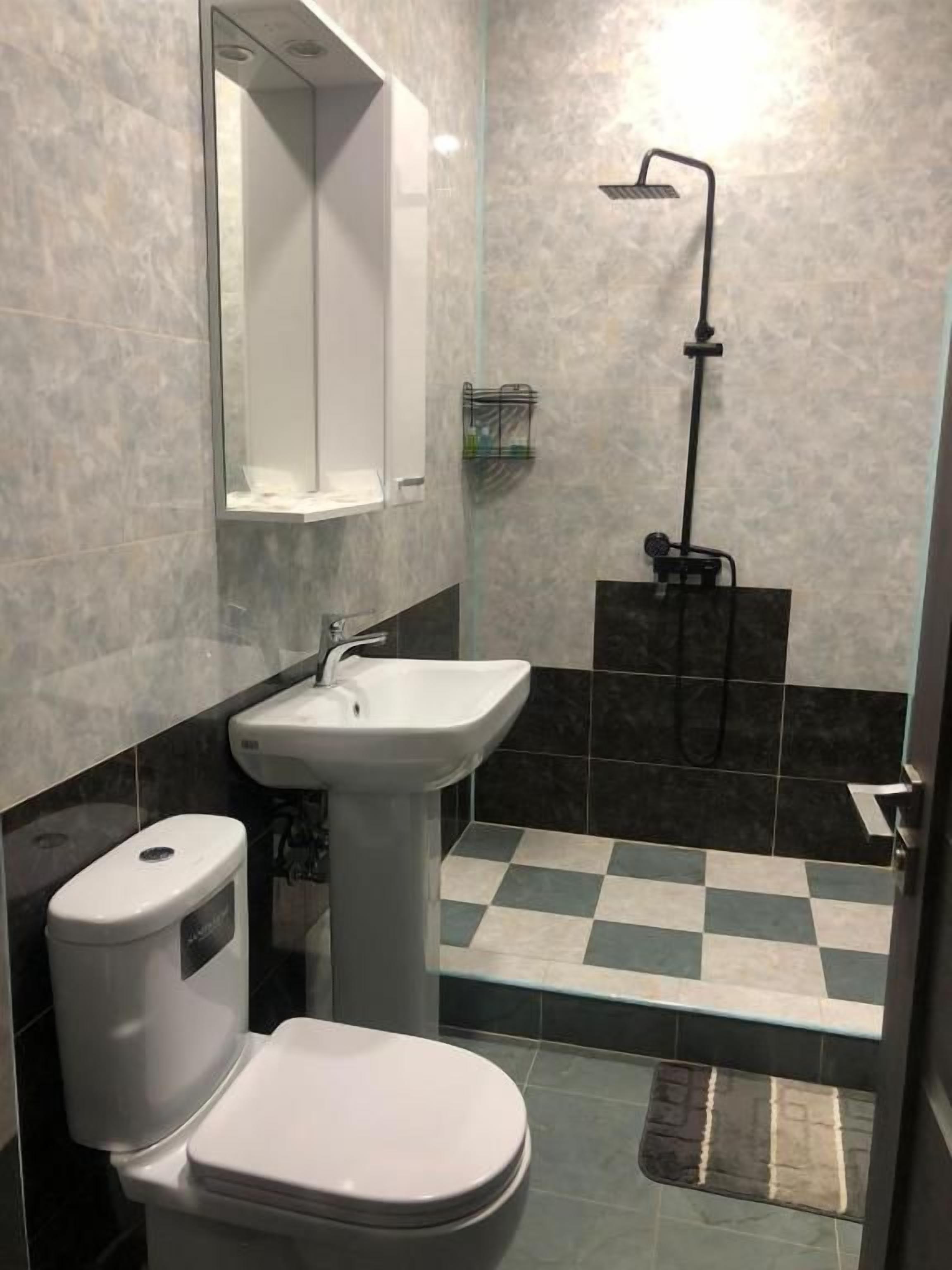 Un baño con inodoro, lavamanos y ducha.