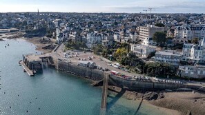 A coastal town with a pier, buildings, and a beach. - Vrbo Property (DINARD)