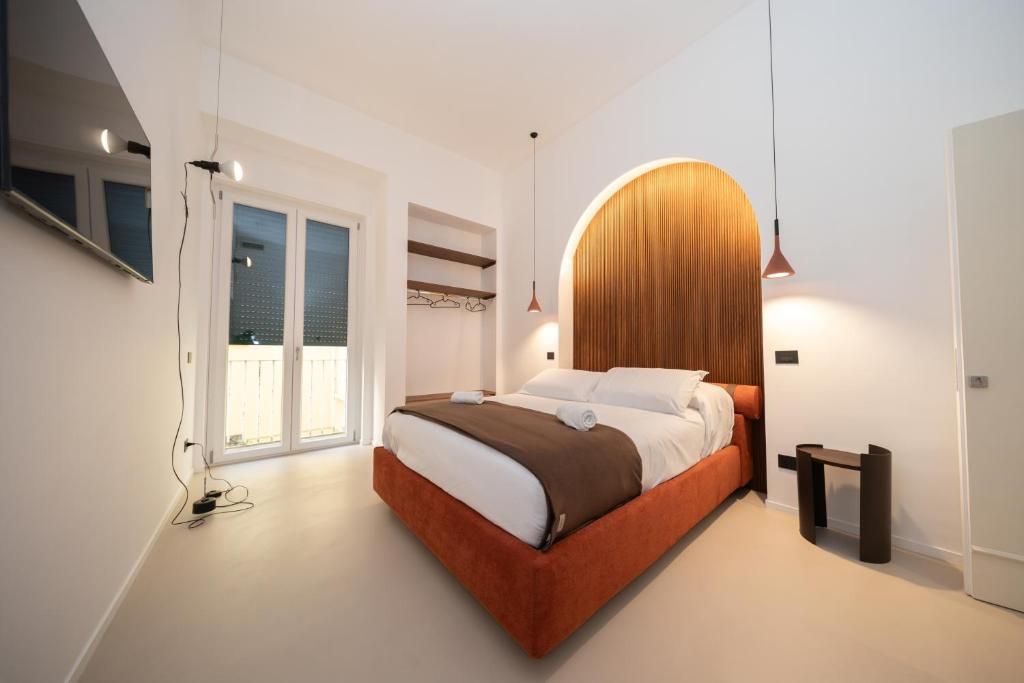 Una camera da letto moderna con un letto grande, una testiera in legno e un comodino.