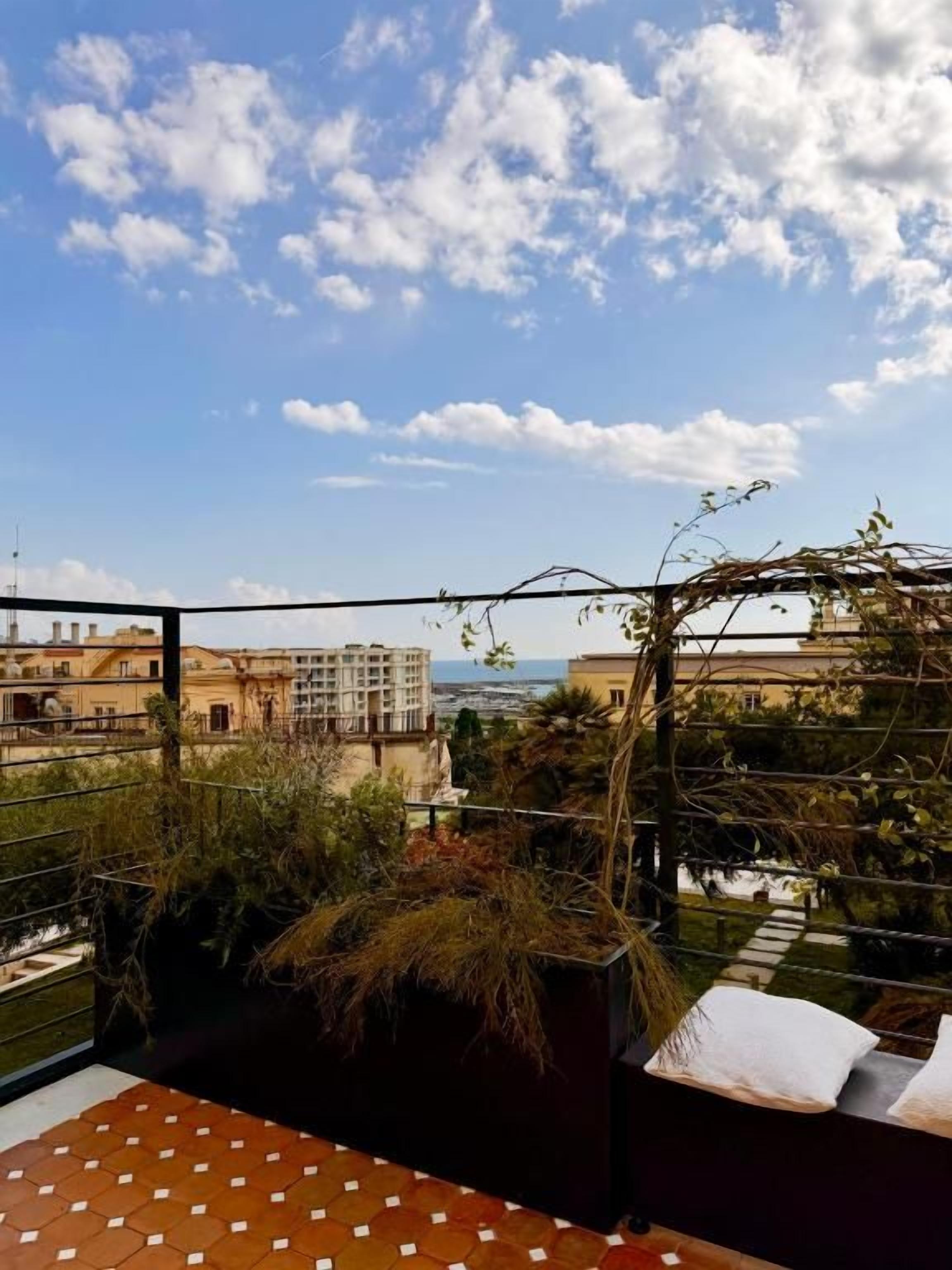 A balcony with a view of buildings and a clear sky.