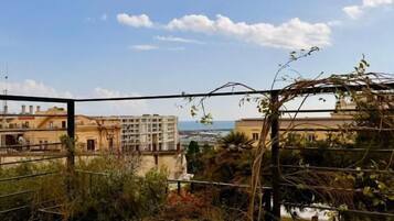 A balcony with a view of buildings and a clear sky.
