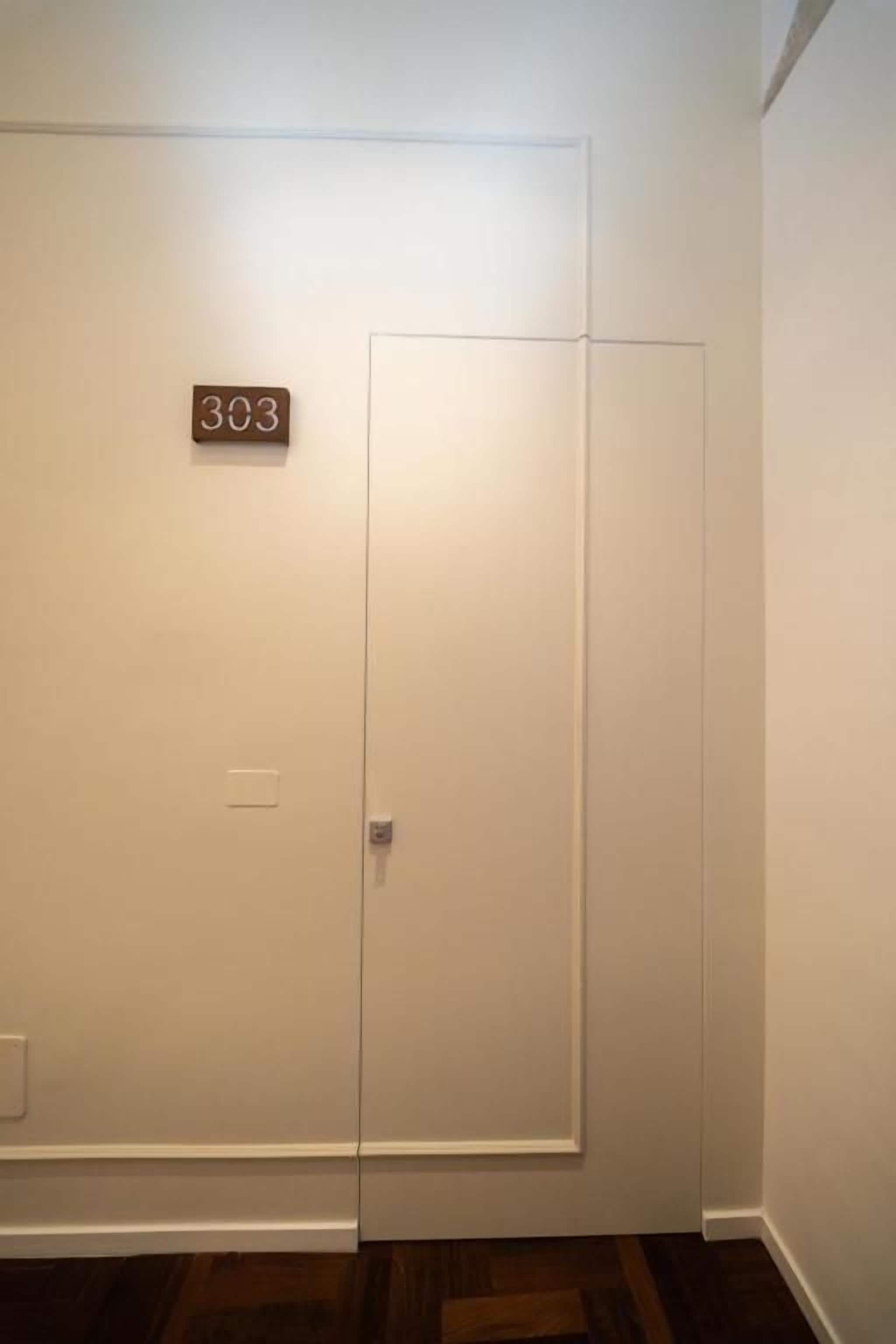 A closed door with a number plate indicating room 303.