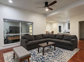 Un salón con un sofá modular, una mesita de centro y un ventanal grande.