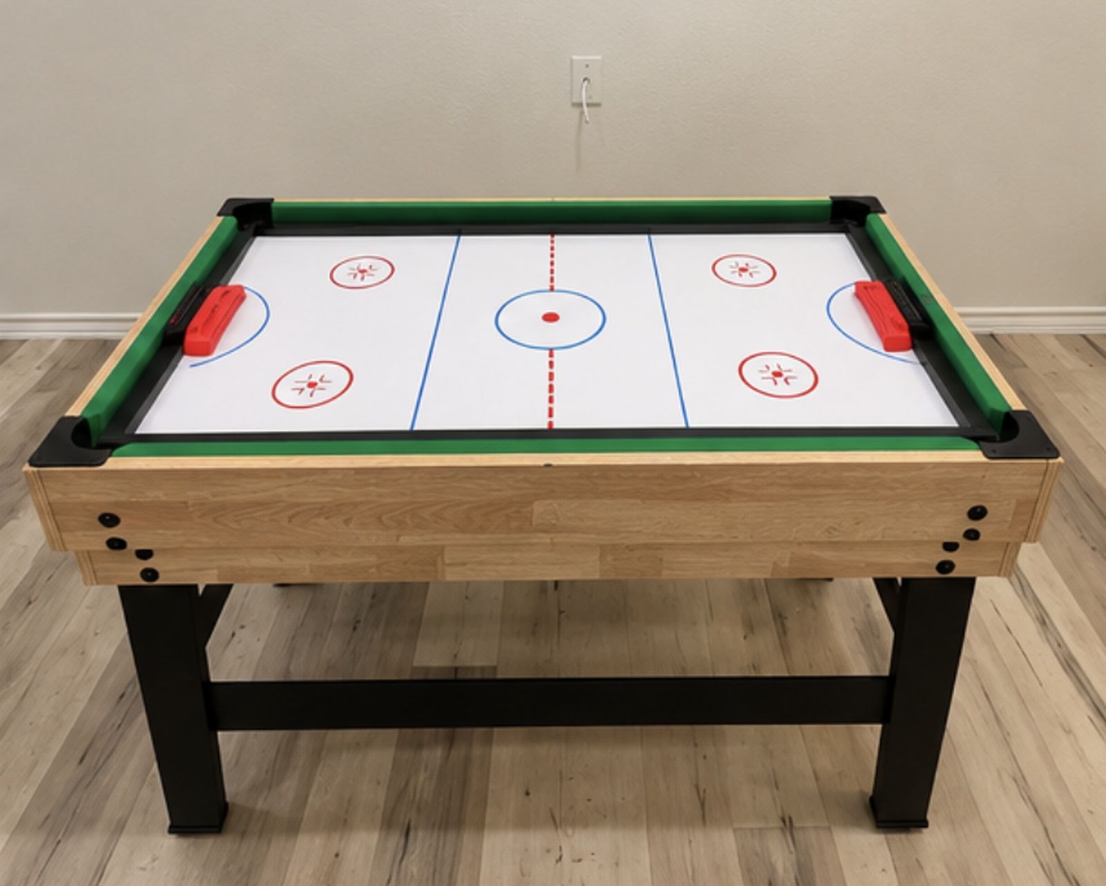 Une table de billard recouverte d’un drap vert, dotée de pieds noirs et d’un cadre en bois.