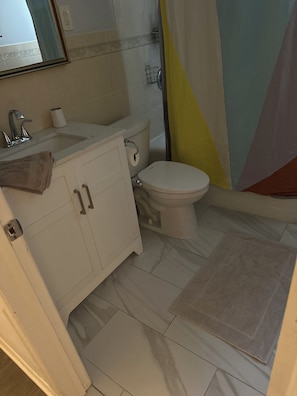 Ein Badezimmer mit Toilette, Waschbecken und Duschbereich.