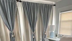 A bedroom with a bed, a desk, a chair, and curtains. - Welcoming 3-bedroom house in Asbury Park Close to Downtown & Beach (Asbury Park)