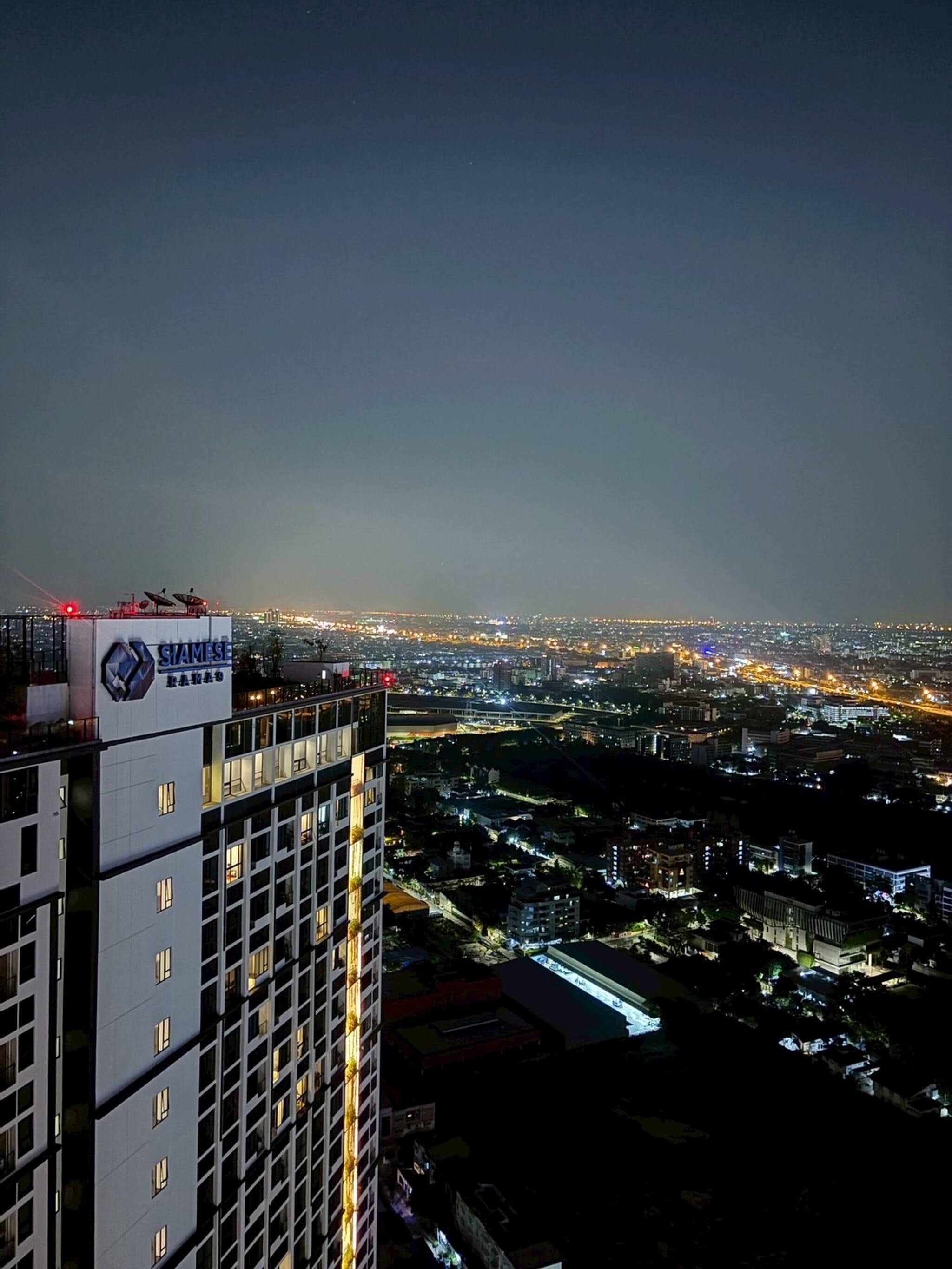 A high-rise building with multiple floors and a cityscape in the background.