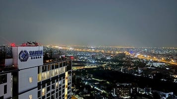 A high-rise building with multiple floors and a cityscape in the background.