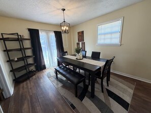 A dining area with a dark wooden table, benches, and a chandelier. - 6 min drive to Ole Miss & Square--Pet Friendly (Oxford)