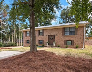 A two-story brick building with a front porch, a welcome sign, and a well-maintained lawn. - 6 min drive to Ole Miss & Square--Pet Friendly (Oxford)
