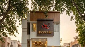 Ein zweistöckiges Gebäude mit einem Schild, auf dem 'Heavens Hut' steht, und einer Treppe, die zum Eingang führt.