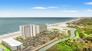 A coastal hotel with multiple buildings, a parking lot, and a river. - Oceanfront 3BR- Brigadune I 17F- Pool (Myrtle Beach)