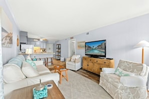 A living room with a sofa, a coffee table, and a television. - Ocean Forest Villas 213E- Outdoor Pool & Hot Tub (Myrtle Beach)