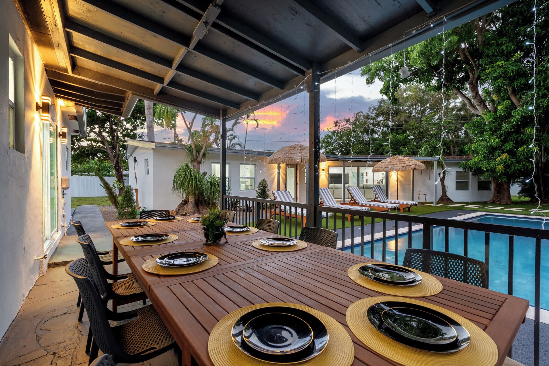 Un espace extérieur aménagé pour les repas, avec une piscine et des chaises longues.
