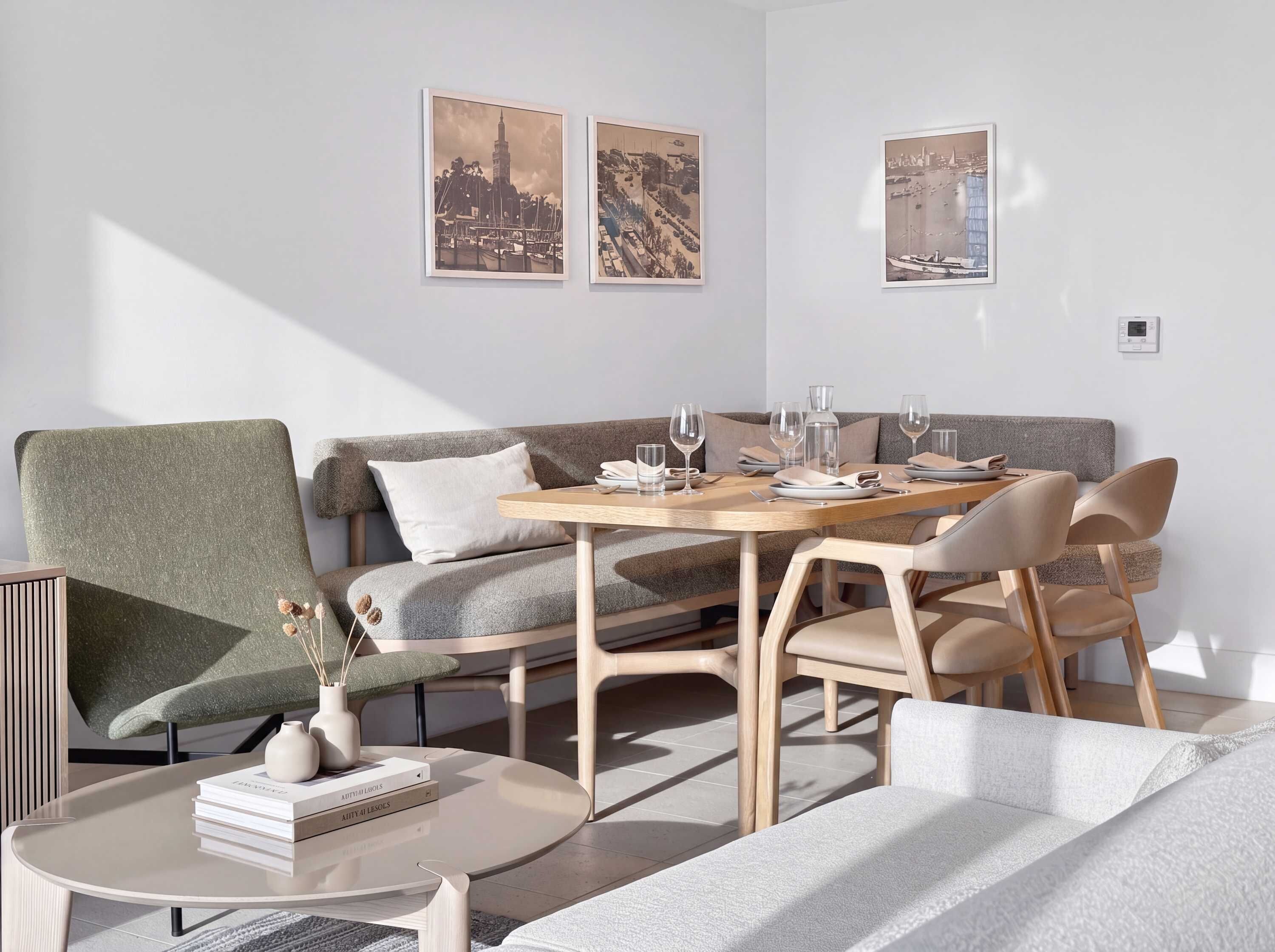 Un comedor moderno con una mesa redonda, sillas y un sofá. Hay cuadros en la pared.