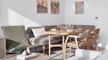 Un comedor moderno con una mesa redonda, sillas y un sofá. Hay cuadros en la pared.