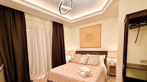 Ein Hotelzimmer mit einem Bett, einer Deckenleuchte, einem Wandbild und einem Kleiderhaken.
