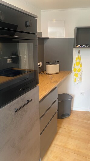 A kitchen with a built-in oven, a microwave, and a toaster on the countertop. - Romantic Vacation Home Galmbacher (Braubach)