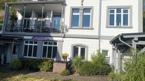 A two-story building with a balcony, a sign for 'la belle COSMETIK INSTITUT,' and a brick planter with yellow flowers. - Romantic Vacation Home Galmbacher (Braubach)