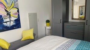 A bedroom with a bed, a bedside table with a plant, a wardrobe, and a painting on the wall. - Romantic Vacation Home Galmbacher (Braubach)