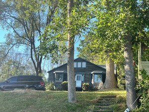 Ein zweistöckiges Haus mit Veranda, Garage und Auffahrt.