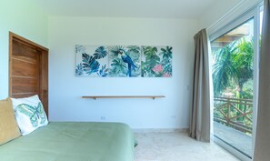 Ein Schlafzimmer mit einem Bett, einem Fenster mit Vorhängen und einer Wand mit einem tropischen Gemälde.