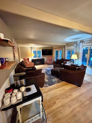 A living room with a sofa set, a coffee table, a TV, and a fireplace. - Cozy 2-bedroom house in tranquil Frederic with AC (Frederic)