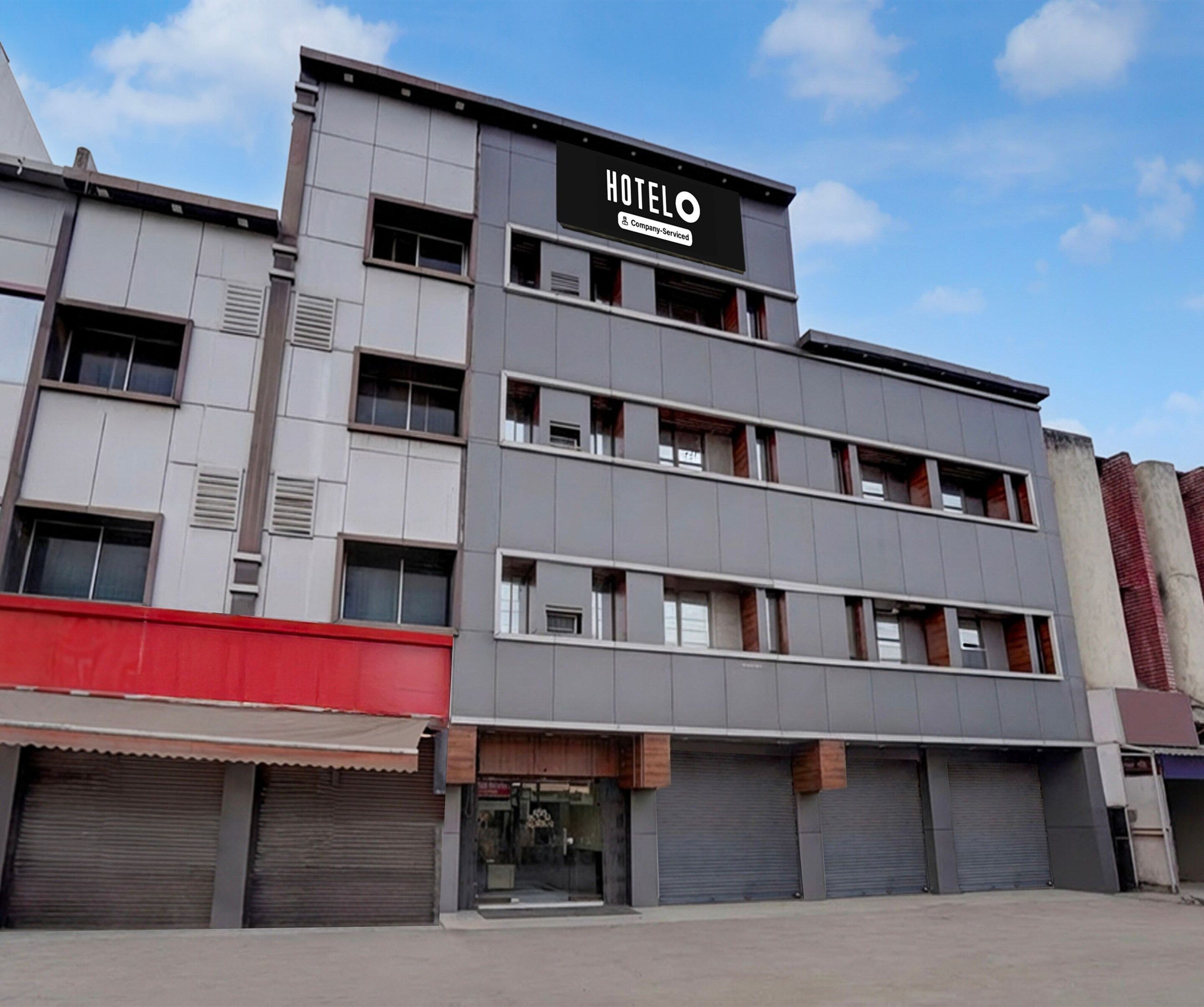 A multi-story hotel building with a sign reading 'HOTEL' and 'Company Serviced.'