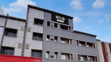 A multi-story hotel building with a sign reading 'HOTEL' and 'Company Serviced.'