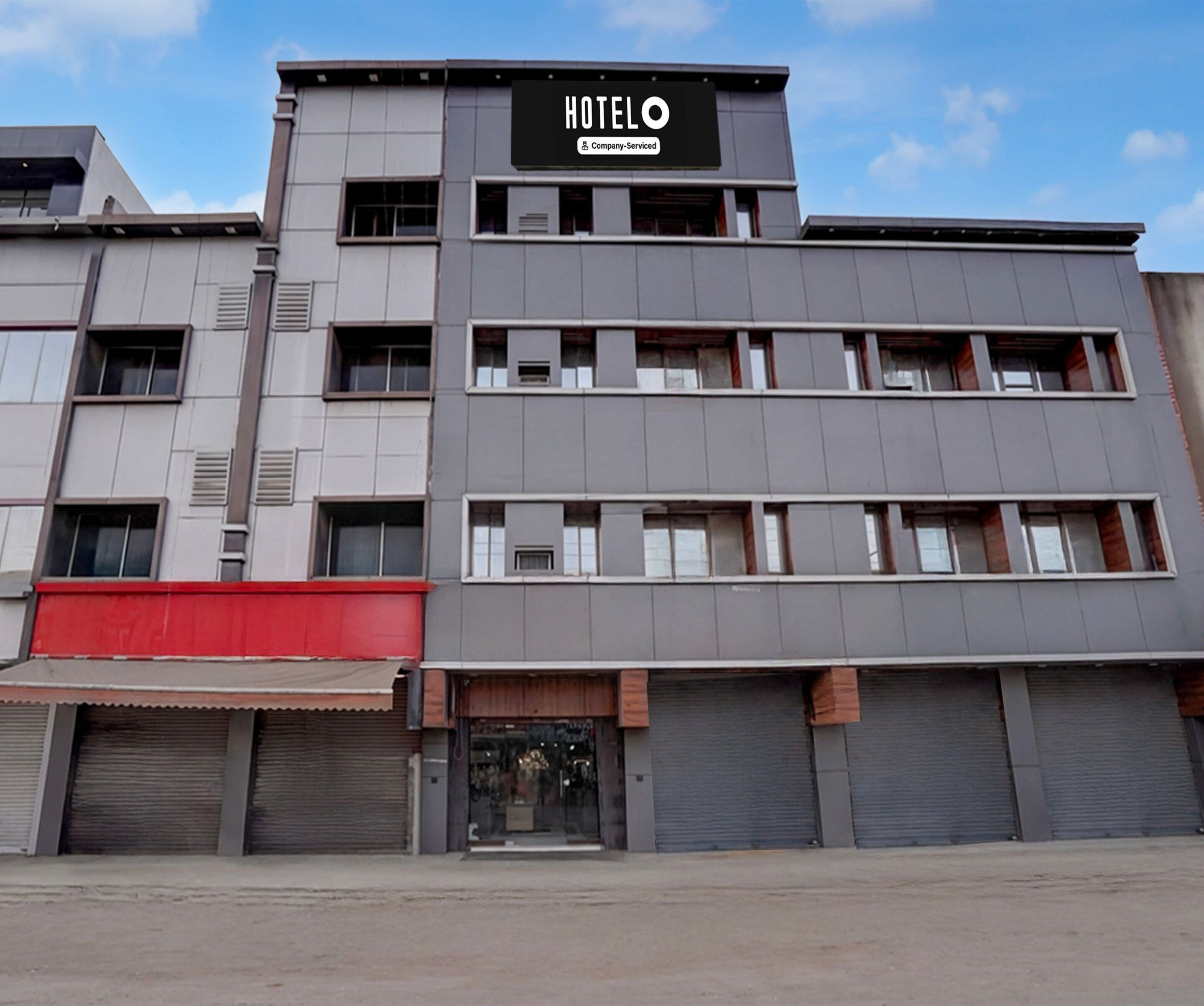 A multi-story hotel building with a prominent sign reading 'HOTELO Company-Serviced'.