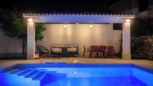 An outdoor pool area with a covered seating area, a sofa, and a table with chairs. - 4-Bedroom Villa in Vis w/ Private Pool & Parking (Vis)