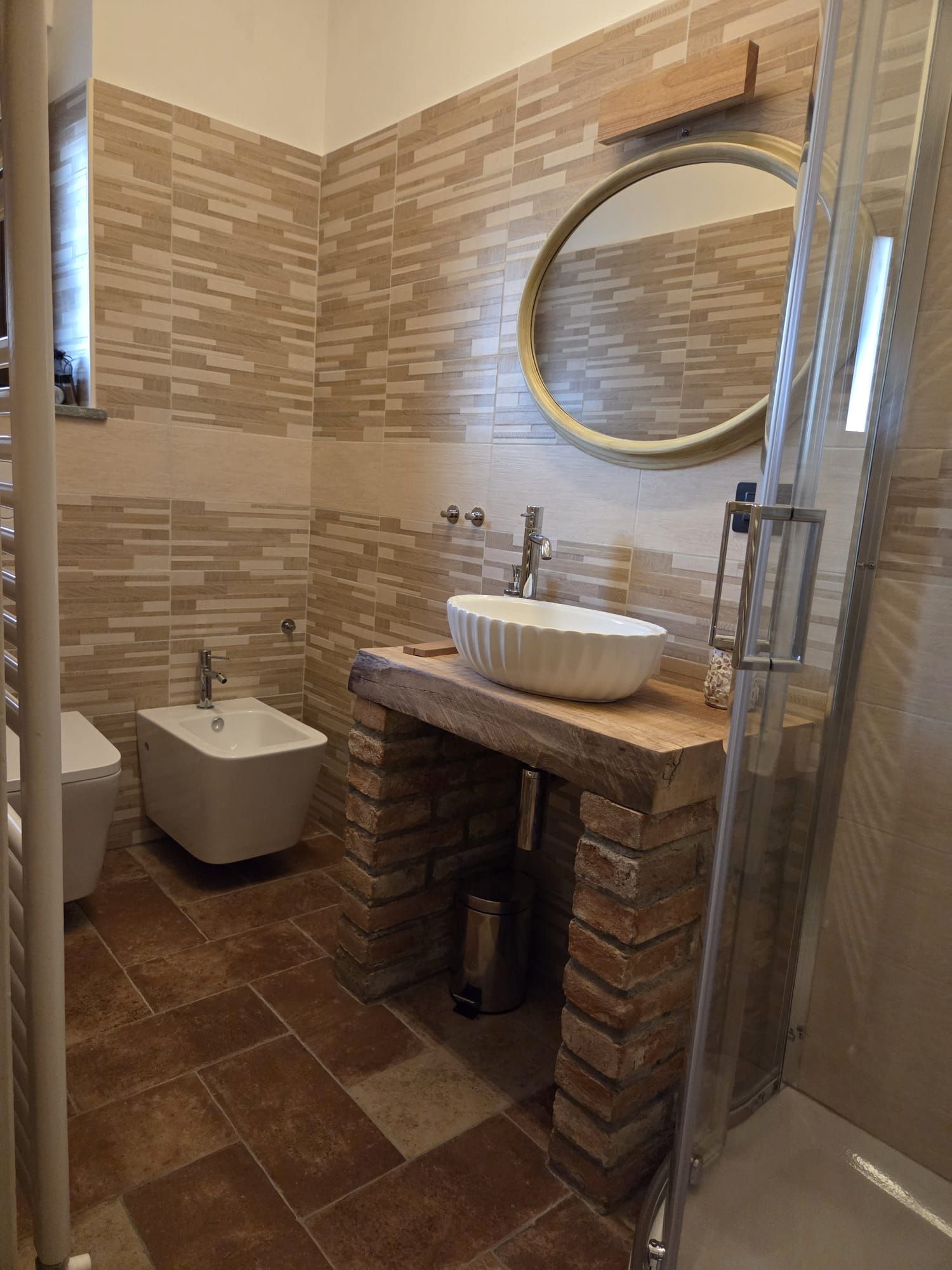 A bathroom with a bidet, a sink with a vessel basin, and a shower area.