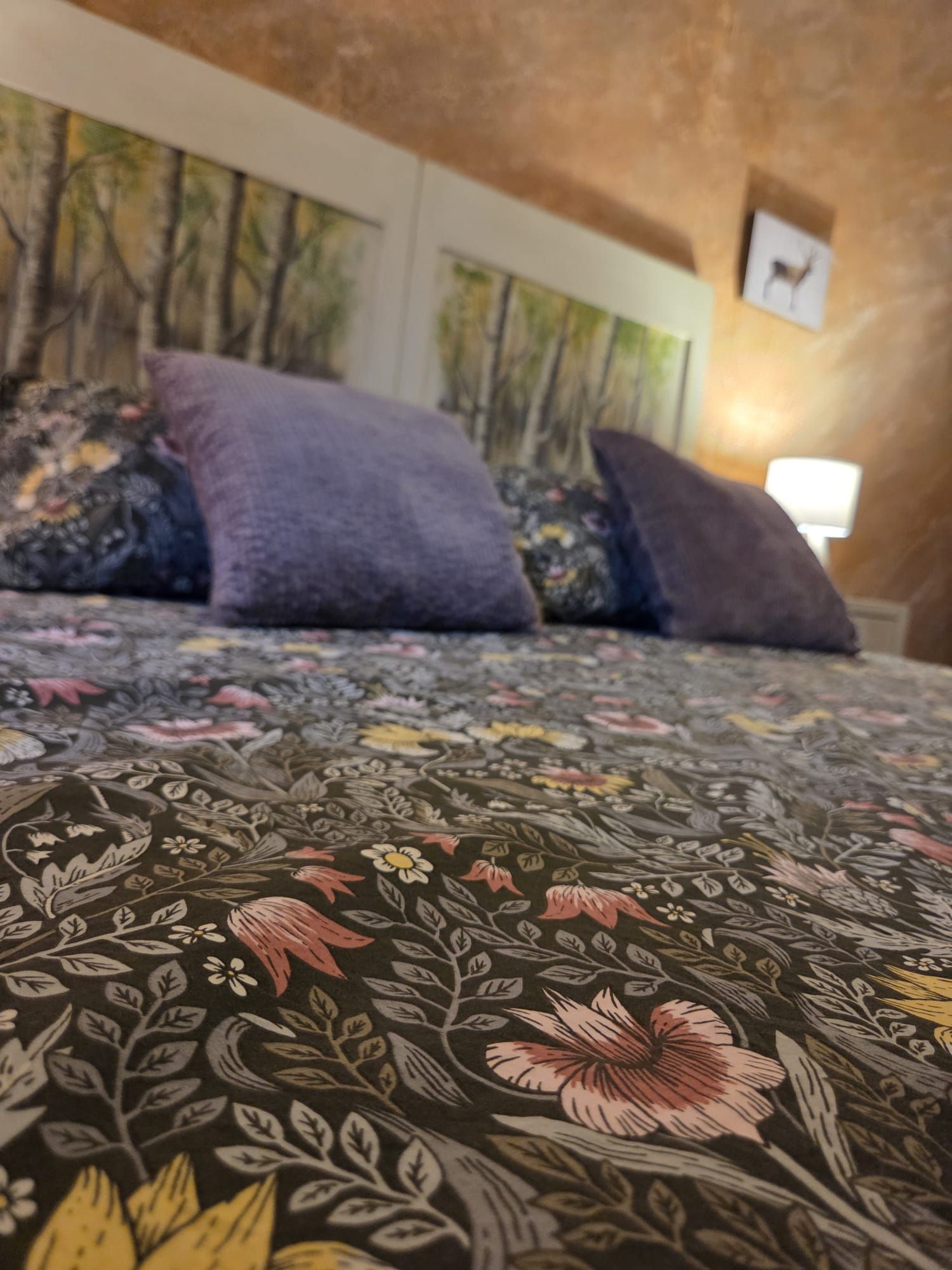 Ein Bett mit blumigem Bettzeug und zwei Kissen.