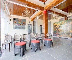 A hotel lobby with a high ceiling, wooden beams, and a large painting of flowers. - Deluxe Nandi Palace (Shri Madhopur)