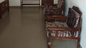 A room with a wooden bench, a table, and patterned chairs. - Rock House (Unawatuna)