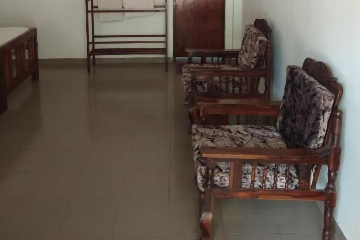Quarto com um banco de madeira, mesa e cadeiras estampadas.