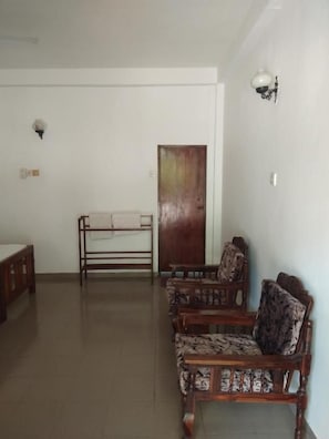Una habitación con un banco de madera, una mesa y sillas estampadas.