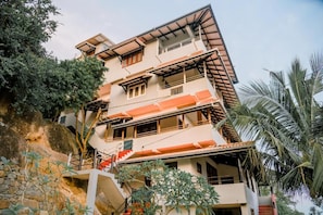 A multi-story building with balconies and a staircase leading to the entrance. - Rock House (Unawatuna)
