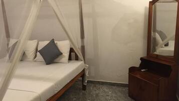 Un dormitorio con una cama con dosel, un aparador de madera y un espejo.