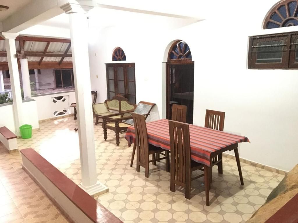A dining area with a table and chairs, a bench, and a window with a view.