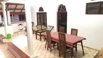 A dining area with a table and chairs, a bench, and a window with a view.