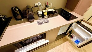Eine Küche mit einer Kaffeebar, einem Wasserkocher, einer Flasche und einem Weinglas.