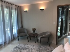 A modern living room with two armchairs, a small table, and a decorative vase. - LOL-HA House, by the sea—a secluded and peaceful spot (Isla Mujeres)