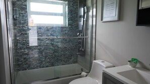 Ein Badezimmer mit einer Duschkabine, einer Toilette und einem Waschbecken.