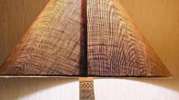 A lamp with a patterned shade and a decorative base on a wooden surface.
