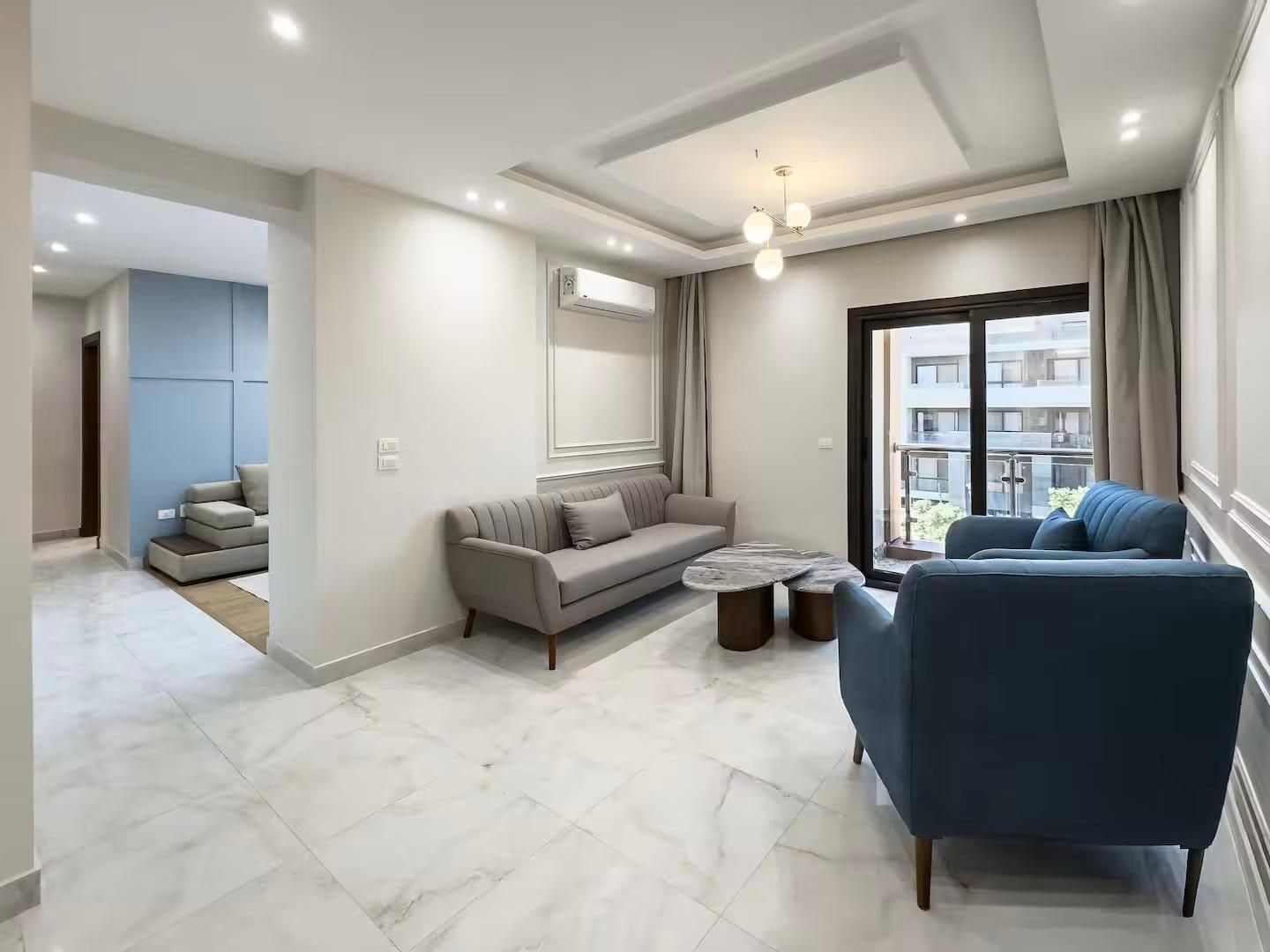 A modern living room with a sofa, armchairs, and a coffee table.