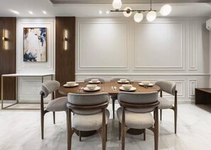 A dining area with a round table set for six, surrounded by six chairs. - Luxury APT - 2BR - La Mirada (IV) (New Cairo City)