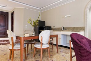 A dining area with a table, chairs, and a vase with flowers. - Luxury APT - 3BR - South Teseen (I) (New Cairo City)